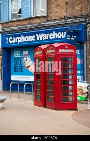 Ursprüngliche alte rote Telefonzellen, die von BT betrieben werden, stehen vor einem Ladengeschäft für Autotelefone, das gerade aufgrund der Entwicklung in der Telefonkommunikationsbranche geschlossen wurde. Bournemouth England (120) Stockfoto