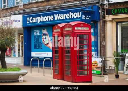 Ursprüngliche alte rote Telefonzellen, die von BT betrieben werden, stehen vor einem Ladengeschäft für Autotelefone, das gerade aufgrund der Entwicklung in der Telefonkommunikationsbranche geschlossen wurde. Bournemouth England (120) Stockfoto