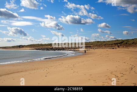 Ein Blick auf den Strand mit einem Hundespaziergänger an der Nord-Norfolk-Küste im Sommer in Sea Palling, Norfolk, England, Großbritannien. Stockfoto