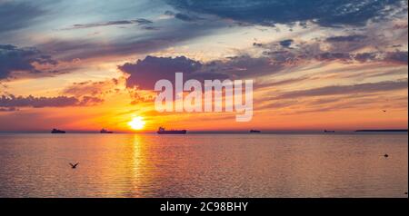 Silhouette von Schiffen im Hintergrund auf See bei schönem Sonnenuntergang Stockfoto