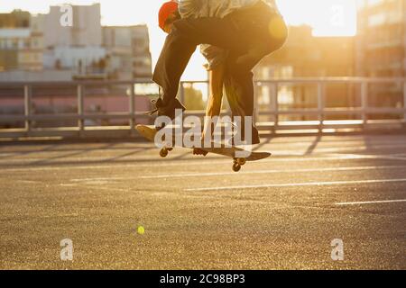 Skateboarder bei der Sommersonne auf der Straße der Stadt. Junger Mann in Turnschuhen und Cap Reiten und Skateboarding auf dem Asphalt. Konzept von Freizeitaktivitäten, Sport, Extremsport, Hobby und Bewegung. Stockfoto