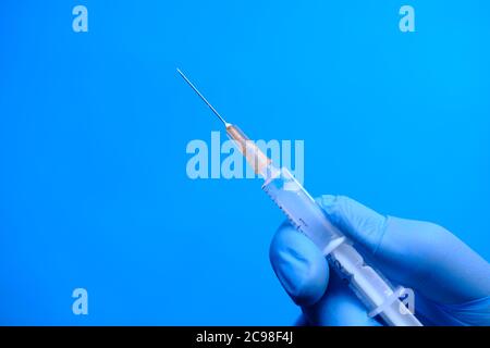 Arzt Hand in medizinischen Handschuhen halten Spritze. Stockfoto