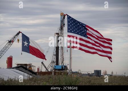 Midland, TX USA 29. Juli 2020: Die Flaggen Texas und USA zieren ein Bohrgerät südöstlich von Midland, TX, wo US-Präsident Donald Trump (nicht abgebildet) am 29. Juli 2020 nach einer Spendenaktion im benachbarten Odessa einen Besuch abstatten wird. Trump wird voraussichtlich Genehmigungen unterzeichnen, die eine stärkere Abhängigkeit von der Ölproduktion im Permian-Becken befürworten.Kredit: Bob Daemmrich/Alamy Live News Stockfoto