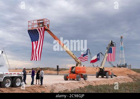 Midland, TX USA 29. Juli 2020: Die Flaggen Texas und USA zieren ein Bohrgerät südöstlich von Midland, TX, wo US-Präsident Donald Trump (nicht abgebildet) am 29. Juli 2020 nach einer Spendenaktion im benachbarten Odessa einen Besuch abstatten wird. Trump wird voraussichtlich Genehmigungen unterzeichnen, die eine stärkere Abhängigkeit von der Ölproduktion im Permian-Becken befürworten.Kredit: Bob Daemmrich/Alamy Live News Stockfoto