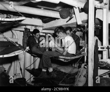 US Navy stellte Männer unter Decks auf Konvoi OKS-14, Juli 1945. Zum 75. Jahrestag des V-J Day hat die Consoli Collection vier Fotoessays von U.S. Navy LT. (j.g.) veröffentlicht. Joseph J. Consoli. Die Fotos wurden zwischen Juli und Dezember 1945 auf den Marianen aufgenommen. Sie dokumentieren das Leben der US-Marine vor und nach der japanischen Kapitulation. Stockfoto