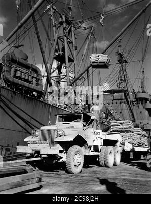 AKA-86 U.S.S. Woodford, Entladen von Fracht in Apre Harbor, Guam, 1945. Zum 75. Jahrestag des V-J Day hat die Consoli Collection vier Fotoessays von U.S. Navy LT. (j.g.) veröffentlicht. Joseph J. Consoli. Die Fotos wurden zwischen Juli und Dezember 1945 auf den Marianen aufgenommen. Sie dokumentieren das Leben der US-Marine vor und nach der japanischen Kapitulation. Stockfoto