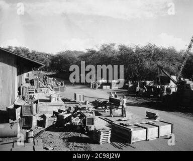 AKA-86 U.S.S. Woodfords Ladung erreicht eine Versorgungsdeponie auf Guam. Zum 75. Jahrestag des V-J Day hat die Consoli Collection vier Fotoessays von U.S. Navy LT. (j.g.) veröffentlicht. Joseph J. Consoli. Die Fotos wurden zwischen Juli und Dezember 1945 auf den Marianen aufgenommen. Sie dokumentieren das Leben der US-Marine vor und nach der japanischen Kapitulation. Stockfoto