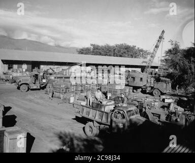 AKA-86 U.S.S. Woodfords Ladung erreicht eine Versorgungsdeponie auf Guam. Zum 75. Jahrestag des V-J Day hat die Consoli Collection vier Fotoessays von U.S. Navy LT. (j.g.) veröffentlicht. Joseph J. Consoli. Die Fotos wurden zwischen Juli und Dezember 1945 auf den Marianen aufgenommen. Sie dokumentieren das Leben der US-Marine vor und nach der japanischen Kapitulation. Stockfoto