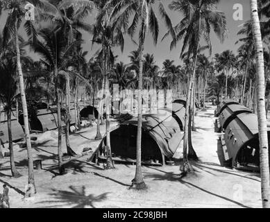 Quarset Hütten am Strand. Camp Dealey Submarine Recuperation Camp. Guam, Juli 1945. Zum 75. Jahrestag des V-J Day hat die Consoli Collection vier Fotoessays von U.S. Navy LT. (j.g.) veröffentlicht. Joseph J. Consoli. Die Fotos wurden zwischen Juli und Dezember 1945 auf den Marianen aufgenommen. Sie dokumentieren das Leben der US-Marine vor und nach der japanischen Kapitulation. Stockfoto