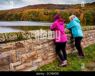 Frau und Mädchen im Teenageralter, die über eine Wand blicken und einen Blick auf das Linacre Reservoir in der Nähe von Chesterfield im Derbyshire Peak District England bewundern. Stockfoto