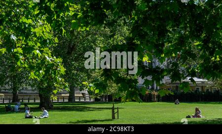 London, Großbritannien. 29. Juli 2020. Wetter in Großbritannien - Büroangestellte nutzen das warme Wetter, um ein Picknick-Mittagessen im St James's Park zu genießen. Für einige ist das Essen außerhalb des Büros die einzige Option, da die Kantinen während der laufenden Coronavirus-Pandemie geschlossen bleiben. Für Freitag, den 31. Juli werden Temperaturen über 30 Grad prognostiziert. Kredit: Stephen Chung / Alamy Live Nachrichten Stockfoto