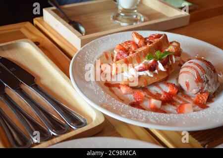 Erdbeerwaffel mit Erdbeersoße und Schokoladeneis. Stockfoto