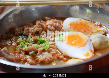 Gehackte Schweinefleischnudeln und Ei mit tom Yum Suppe kochen Stockfoto