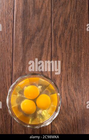 Drei rohe Eier in einer Glasschüssel. Der Inhalt von Hühnereiern zum Kochen von Eiern und anderen Gerichten. Stockfoto
