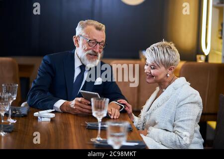 Schöne ältere Paar verbringen Zeit zusammen in einem reichen Restaurant Blick auf Gadget, Lächeln, fröhlich Stockfoto