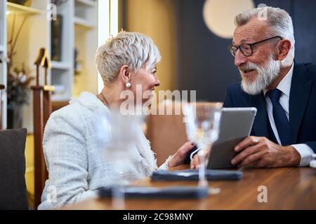 Schöne ältere Paar verbringen Zeit zusammen in einem reichen Restaurant Blick auf Gadget, Lächeln, fröhlich Stockfoto