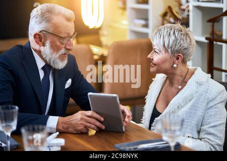 Schöne ältere Paar verbringen Zeit zusammen in einem reichen Restaurant Blick auf Gadget, Lächeln, fröhlich Stockfoto