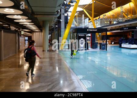 28. Juli 2020, Barajas Airport, Madrid, Spanien: Passagiere gehen durch den nahe gelegenen Abflugbereich des Terminal 4S Gebäudes des Barajas Airport. Die Zahl der Flüge zwischen den europäischen Ländern ist nach der Sperre reduziert, um das COVID-19-Coronavirus zu kontrollieren, und die Regierungen haben ein System von Luftbrücken eingeführt, um Reisen und Tourismus zu erleichtern. Spanien hat in den letzten Tagen eine Reihe neuer Ausbrüche erlebt, was die britische Regierung dazu veranlasste, bekannt zu geben, dass Menschen, die aus Spanien nach Großbritannien zurückkehren, nach ihrer Ankunft 14 Tage lang in Quarantäne gehen sollten. Stockfoto