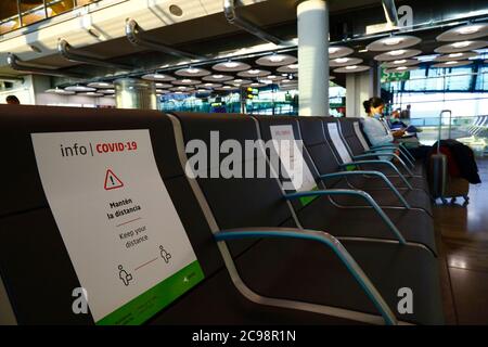 28. Juli 2020, Flughafen Barajas, Madrid, Spanien: Schilder auf den Sitzen, die den Passagieren helfen, die soziale Distanz im nahe geleerten Abflugbereich des Terminal 4S-Gebäudes des Flughafens Barajas einzuhalten. Die Zahl der Flüge zwischen den europäischen Ländern ist nach der Sperre reduziert, um das COVID-19-Coronavirus zu kontrollieren, und die Regierungen haben ein System von Luftbrücken eingeführt, um Reisen und Tourismus zu erleichtern. Spanien hat in den letzten Tagen eine Reihe neuer Ausbrüche erlebt, was die britische Regierung dazu veranlasste, bekannt zu geben, dass Menschen, die aus Spanien nach Großbritannien zurückkehren, nach ihrer Ankunft 14 Tage lang in Quarantäne gehen sollten. Stockfoto