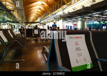 28. Juli 2020, Flughafen Barajas, Madrid, Spanien: Schilder auf den Sitzen, die den Passagieren helfen, die soziale Distanz im nahe geleerten Abflugbereich des Terminal 4S-Gebäudes des Flughafens Barajas einzuhalten. Die Zahl der Flüge zwischen den europäischen Ländern ist nach der Sperre reduziert, um das COVID-19-Coronavirus zu kontrollieren, und die Regierungen haben ein System von Luftbrücken eingeführt, um Reisen und Tourismus zu erleichtern. Spanien hat in den letzten Tagen eine Reihe neuer Ausbrüche erlebt, was die britische Regierung dazu veranlasste, bekannt zu geben, dass Menschen, die aus Spanien nach Großbritannien zurückkehren, nach ihrer Ankunft 14 Tage lang in Quarantäne gehen sollten. Stockfoto