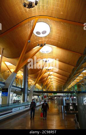 28. Juli 2020, Barajas Airport, Madrid, Spanien: Passagiere gehen durch den nahe gelegenen Loungebereich der Abflugstore des Terminal 4S Gebäudes des Barajas Airport. Die Zahl der Flüge zwischen den europäischen Ländern ist nach der Sperre reduziert, um das COVID-19-Coronavirus zu kontrollieren, und die Regierungen haben ein System von Luftbrücken eingeführt, um Reisen und Tourismus zu erleichtern. Spanien hat in den letzten Tagen eine Reihe neuer Ausbrüche erlebt, was die britische Regierung dazu veranlasste, bekannt zu geben, dass Menschen, die aus Spanien nach Großbritannien zurückkehren, nach ihrer Ankunft 14 Tage lang in Quarantäne gehen sollten. Stockfoto