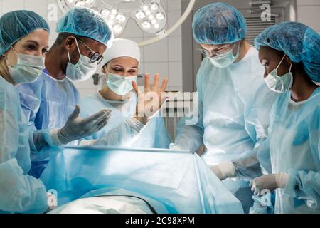 Der Patient steht auf, während Chirurgen macht einen kleinen Schnitt, Nahaufnahme Foto. Stockfoto