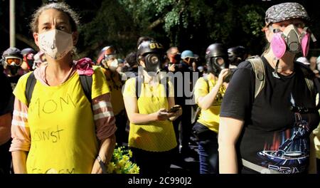 Portland, Oregon, USA. Juli 2020. Proteste In Portland: Weiße Mütter, viele, die noch nie zuvor protestiert haben, versammeln sich an der Front vor dem Justizzentrum, um ihre Körper zu einem menschlichen Schild zu machen, um die anderen Demonstranten vor den Kugeln und Tränengas zu schützen, die seit der Ankunft der Feds in Portland jede Nacht stundenlang gespritzt wurden. Sie sind schockiert und bestürzt darüber, dass die Federal Agents, die vom Präsidenten geschickt wurden, Feuer auf sie eröffnet, was massive Verletzungen verursacht. Sie kommen sowieso immer wieder. Quelle: Amy Katz/ZUMA Wire/Alamy Live News Stockfoto