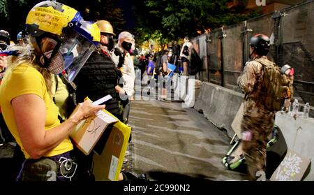 Portland, Oregon, USA. Juli 2020. Proteste In Portland: Weiße Mütter, viele, die noch nie zuvor protestiert haben, versammeln sich an der Front vor dem Justizzentrum, um ihre Körper zu einem menschlichen Schild zu machen, um die anderen Demonstranten vor den Kugeln und Tränengas zu schützen, die seit der Ankunft der Feds in Portland jede Nacht stundenlang gespritzt wurden. Sie sind schockiert und bestürzt darüber, dass die Federal Agents, die vom Präsidenten geschickt wurden, Feuer auf sie eröffnet, was massive Verletzungen verursacht. Sie kommen sowieso immer wieder. Quelle: Amy Katz/ZUMA Wire/Alamy Live News Stockfoto