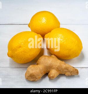 Drei Zitronen und Ingwerwurzel auf weißem Holzhintergrund Stockfoto