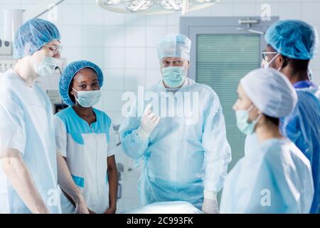 Talentierte Chirurgen im Operationssaal im Krankenhaus sprechen, mit einem Gespräch. Nahaufnahme Foto. Job, Beruf Stockfoto