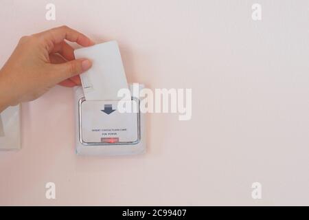 Soft Focus on Hand legen Sie Schlüsselkarte für elektrische Geräte auf dem Hotelzimmer, Hotel Lock Energy Control System Stockfoto