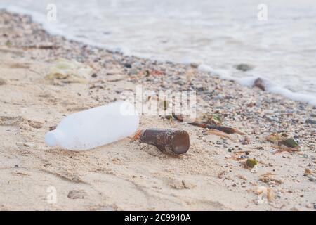 Weicher Fokus auf Plastikflaschen und andere Arten von Plastikmüll am Strand. Stockfoto