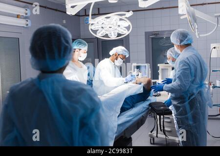 Foto von anästhesisten mit Maske Vorbereitung der Patienten auf die Chirurgie in modernen Betrieb Theater Stockfoto