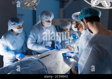 Team-Arbeit von Chirurgen, die Chirurgie an einem Patienten unter Narkose im Krankenhaus. Stockfoto