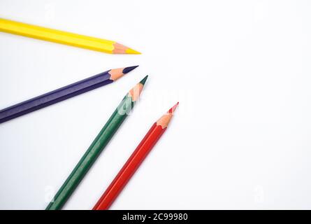 Rot gelb blau und grün gefärbte Holz Bleistift Buntstifte auf einem Papier Hintergrund platziert Stockfoto