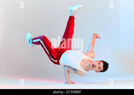 Isolierte koreanische Hip-Hop männliche brechen Tänzer tanzen auf weißem Hintergrund, Durchführung Air Chair Element von Downrock Breakdance Stockfoto