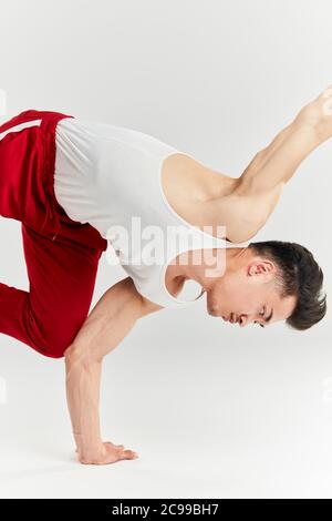 Asiatisch männlich gekleidet in weißen Unterhemd und rote sportliche Hose Vorbereitung zum Tanz Wettbewerb zu brechen, arbeiten Schulter frieren Haltung Stockfoto