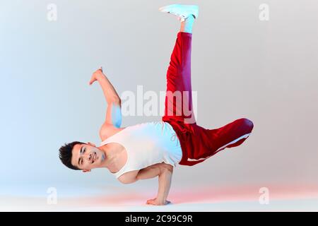 Hip-Hop koreanische Break-Tänzerin in roten Sweathosen bleiben in weißen Klassenzimmer den ganzen Tag und lernen Choreographie von anderen Menschen gemacht, trainieren über Technik Stockfoto