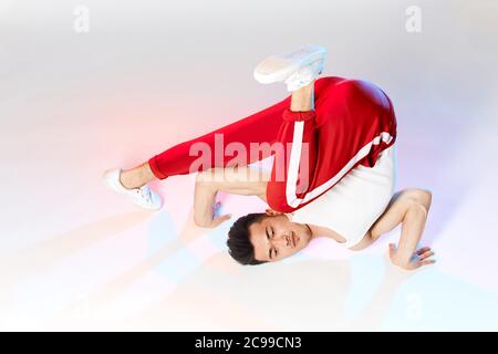 Hip-Hop koreanische Break-Tänzerin in roten Sweathosen bleiben in weißen Klassenzimmer den ganzen Tag und lernen Choreographie von anderen Menschen gemacht, trainieren über Technik Stockfoto