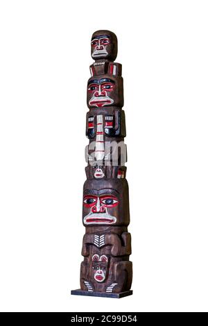 Ein altes afrikanisches Totem aus Holz, geschnitzt und von Hand bemalt. Es zeigt indigene schwarze Männer, die übereinander sitzen. Souvenirs für Touristen. Stockfoto