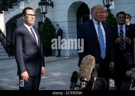US-Finanzminister Steven Mnuchin hört zu, wie US-Präsident Donald J. Trump vor dem Weißen Haus in Washington, DC, USA, am Mittwoch, den 29. Juli 2020, vor der Presse spricht. Quelle: Sarah Silbiger/Pool via CNP /MediaPunch Stockfoto