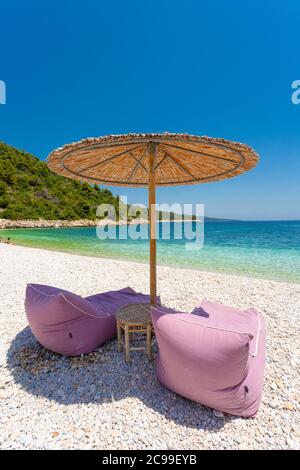 Liegestühle und Sonnenschirm am Leftos Gialos Strand, Alonnisos, Griechenland Stockfoto