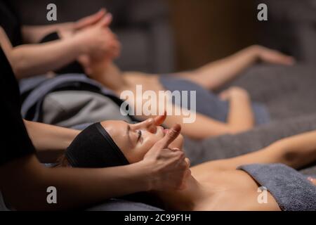 Junge und schöne Frau liegen auf Massage-Schreibtisch, entspannen und genießen, erhalten gesunde Behandlung der Haut, in Luxus-Wellness-Center Stockfoto