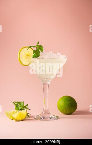 Cocktail margarita garniert mit Limette und Minze auf rosa Hintergrund Stockfoto