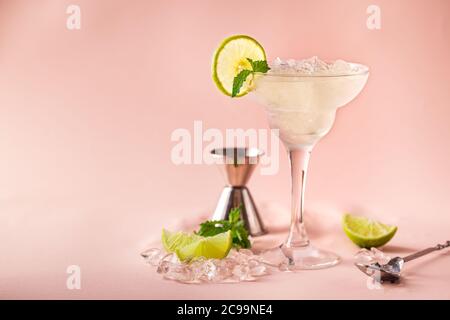 Cocktail margarita garniert mit Limette und Minze auf rosa Hintergrund Stockfoto