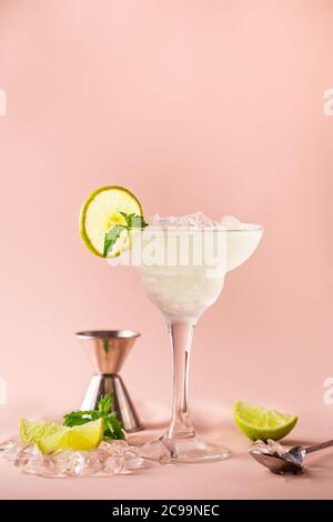 Cocktail margarita garniert mit Limette und Minze auf rosa Hintergrund Stockfoto