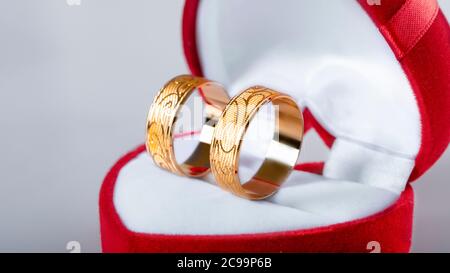 Zwei Eheringe in einer roten herzförmigen Schachtel Stockfoto