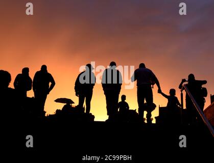 Silhouetten von Menschen gegen den Abendhimmel Stockfoto
