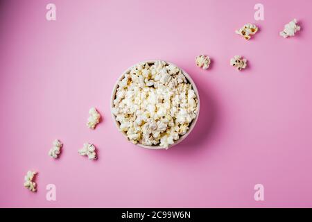 Eine rosa Schale Popcorn auf rosa Hintergrund, Draufsicht Stockfoto