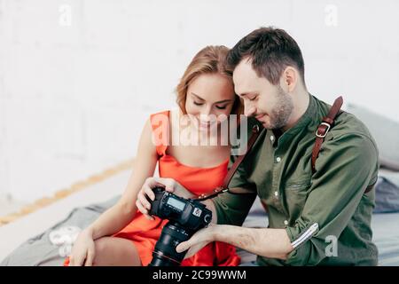 Junges Paar Überprüfung gute Fotos, während auf dem Sofa sitzen, Nahaufnahme Foto. Glückliche Mann und Frau Auswahl der besten Fotos nach der Fotosession, erfolgreich Stockfoto